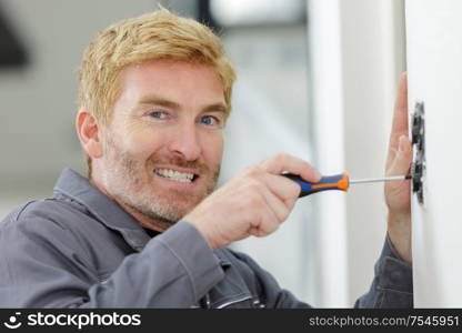 electrician with a screwdriver during the installation