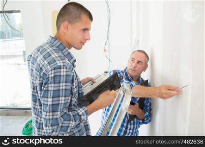electrician with apprentice working in new home