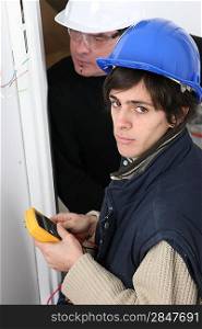 Electrician with young apprentice