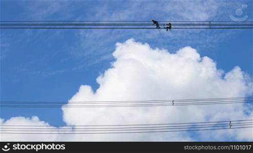 Electrician work installation of high voltage cable in high voltage safely and systematically over and blue sky background.