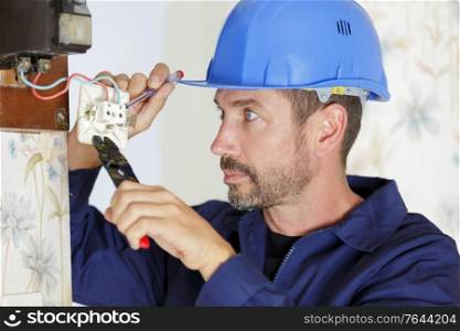 electrician working on old electric panel