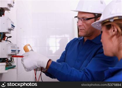 Electricians fitting a fusebox