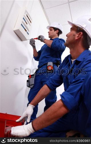 Electricians installing circuit breaker