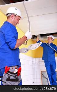 Electricians installing electrical cabling
