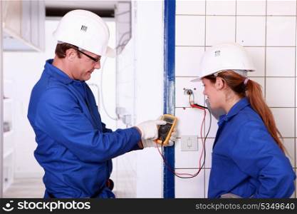 Electricians with voltmeter