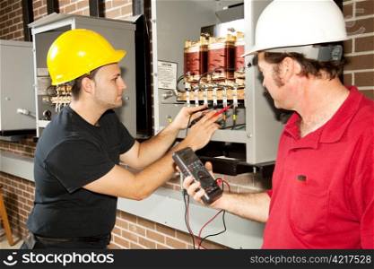 Electricians working on an industrial power distribution center. Actual electricians and authentic accurate content.