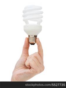 electricity and energy concept - close up of woman hand holding energy efficient light bulb