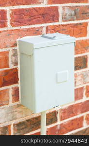 Electricity control box on a red brick wall