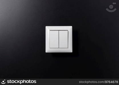 electricity, energy and power consumption concept - close up of light switch on black background. close up of light switch on black background