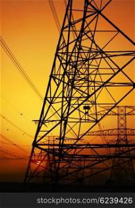 Electricity Pylon over orange sunset sky. Environmental damage