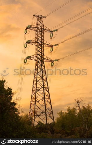 Electricity pylon with clouds and trees in the backround