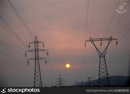 electricity pylons on highway, sunset