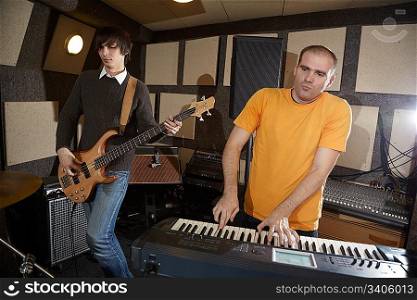 electro guitar player and keyboarder working in studio