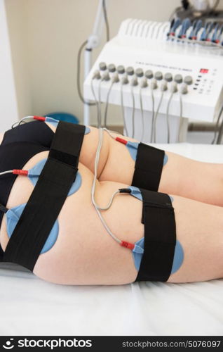 electro stimulation therapy. Body treatment: middle aged woman getting getting electro stimulation therapy to her buttocks