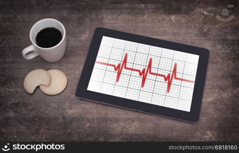 Electrocardiogram on a tablet - Concept of healthcare, heartbeat shown on monitor - red