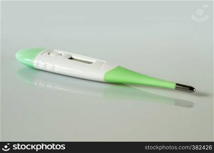 Electronic digital medical thermometer on a grey background. Digital medical thermometer
