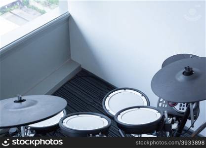 Electronic drum set in the room corner as musical background technology theme
