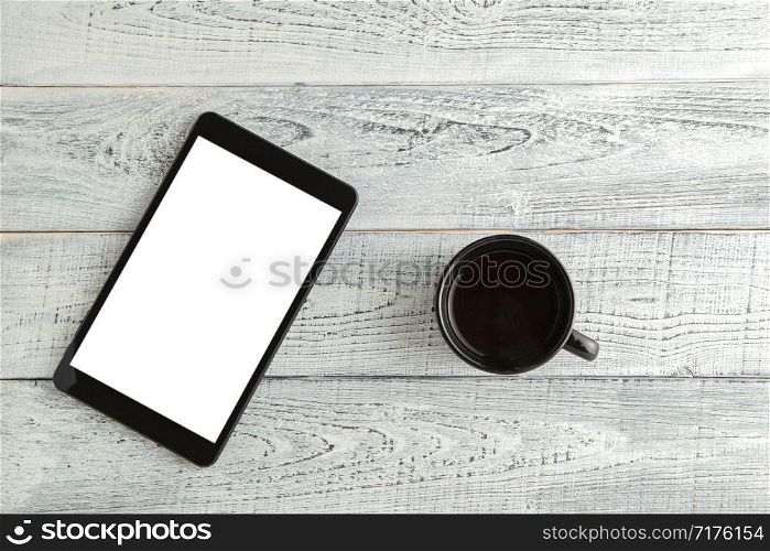 electronic tablet with a Cup of tea or coffee on a vintage shabby white wooden background. the view from the top. flat lay