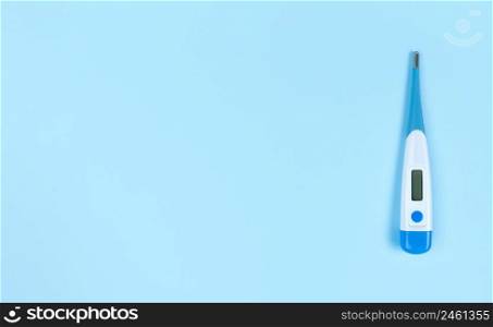 Electronic thermometer on a blue background with copy space.. Electronic thermometer on blue background with copy space.