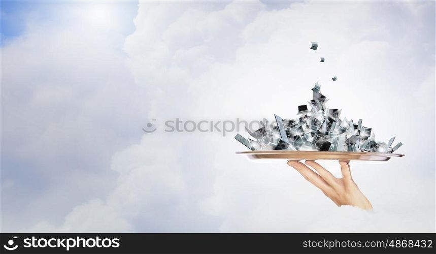 Electronics and computer service . Hand holding metal tray with pile of electronic devices