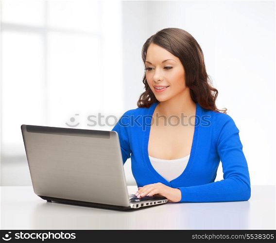 electronics and gadget concept - smiling woman in blue clothes with laptop computer