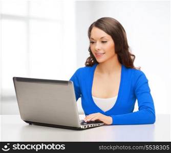 electronics and gadget concept - smiling woman in blue clothes with laptop computer