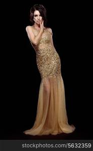 Elegance. Aristocratic Lady in Golden Long Dress over Black Background