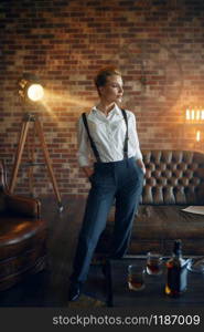 Elegance business woman in strict clothes poses in studio, retro fashion, gangster style, mafia. Vintage lady in office with brick walls. Elegance business woman in strict clothes, retro