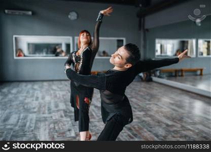 Elegance dancers in costumes on ballrom dance training in class. Female and male partners on professional pair dancing in studio
