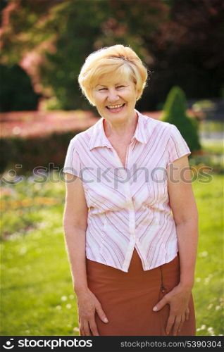 Elegance. Elation. Happy Senior Woman Outside with Toothy Smile