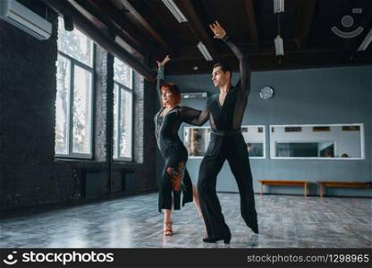 Elegance man and woman in costumes on ballrom dance training in class. Female and male partners on professional pair dancing in studio. Elegance man and woman on ballrom dance training