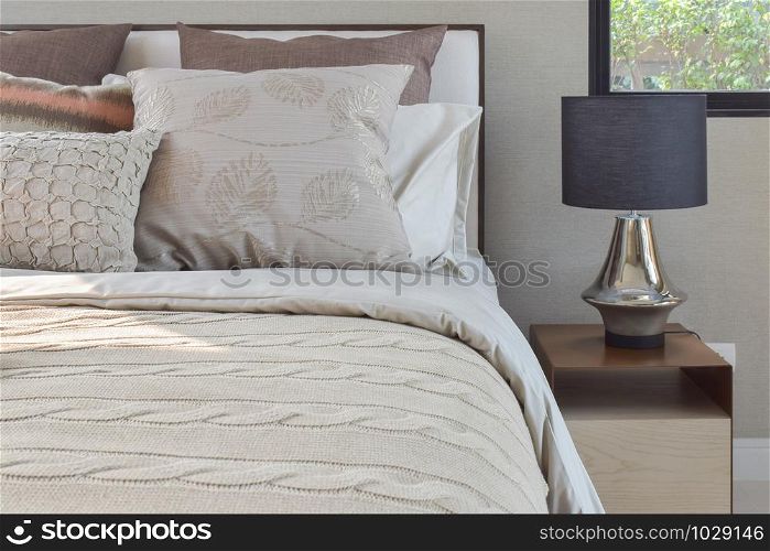 Elegance style pillows setting on classic style bedding and reading lamp on bedside table
