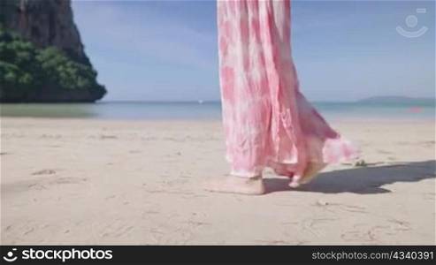 Elegance woman legs walking on the island beach, small calm waves on. Hot sunny weather, clear ocean water, travel package plan reservation, summer vacation, side view, horizon seascape and sky