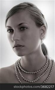 elegant and attractive woman with pearl necklace in a desaturate shot
