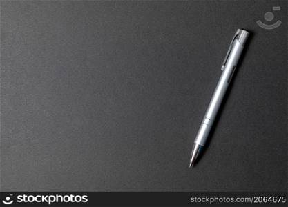 Elegant and luxury metal ballpoint pen on black stone background