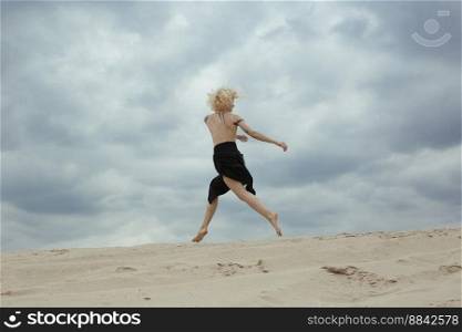 Elegant bare woman jumping on beach scenic photography. Picture of person with overcast sky on background. High quality wallpaper. Photo concept for ads, travel blog, magazine, article. Elegant bare woman jumping on beach scenic photography