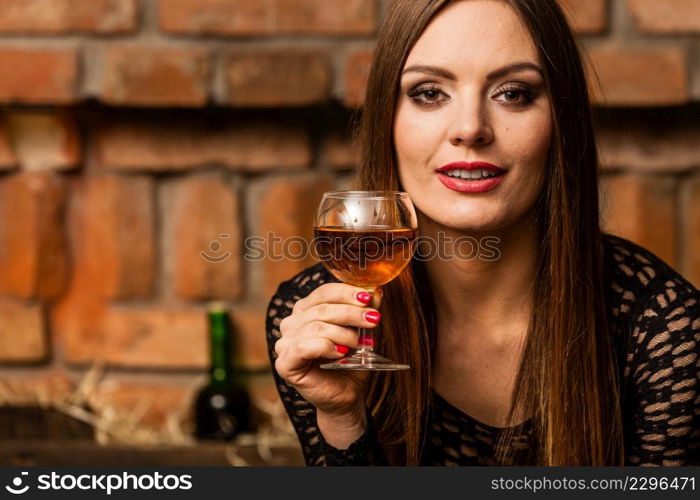 Elegant beauty lady long hair full make up wearing black dress tasting wine in rural cottage interior celler. Woman tasting wine in rural cottage interior