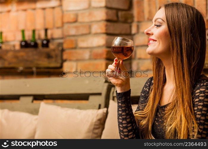 Elegant beauty lady long hair full make up wearing black dress tasting wine in rural cottage interior celler. Woman tasting wine in rural cottage interior