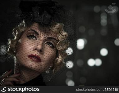 Elegant blond retro woman with red lipstick wearing little hat with veil