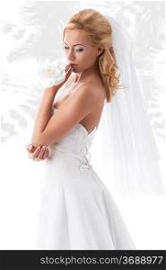 elegant blonde bride with splendid wedding dress, floral decoration on hand. Feathered pattern on background