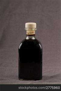Elegant bottle of balsamic vinegar over brown background