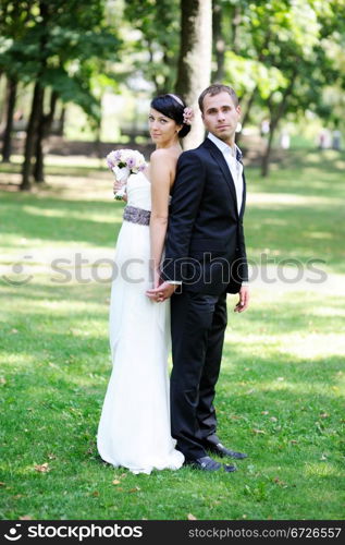 Elegant bride and groom posing together outdoors on a wedding day