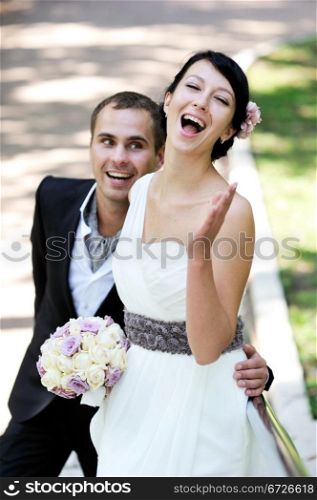 Elegant brunette bride and happy groom celebrating their wedding day, focus on bride