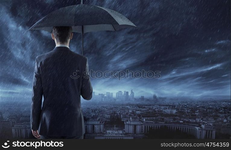 Elegant businessman staring at the town in the night
