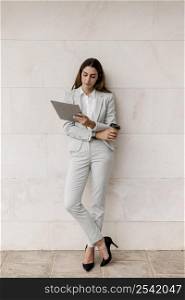 elegant businesswoman holding tablet coffee cup
