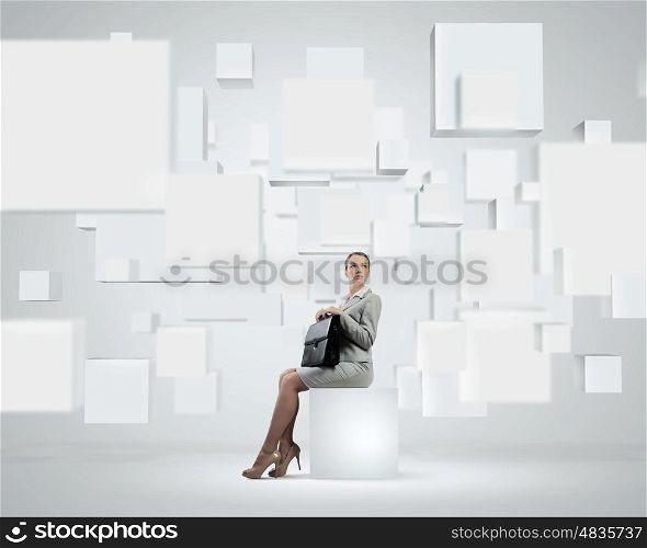 Elegant businesswoman. Image of elegant businesswoman sitting on white cube touching media button