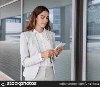 elegant businesswoman using smartphone outdoors