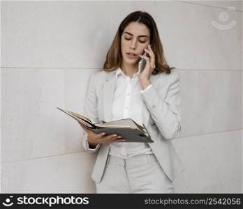 elegant businesswoman with agenda talking phone