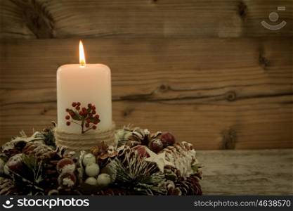 Elegant centerpiece for the Christmas table with a candle on a natural wreath