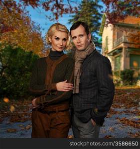 Elegant couple against country house on autumn day